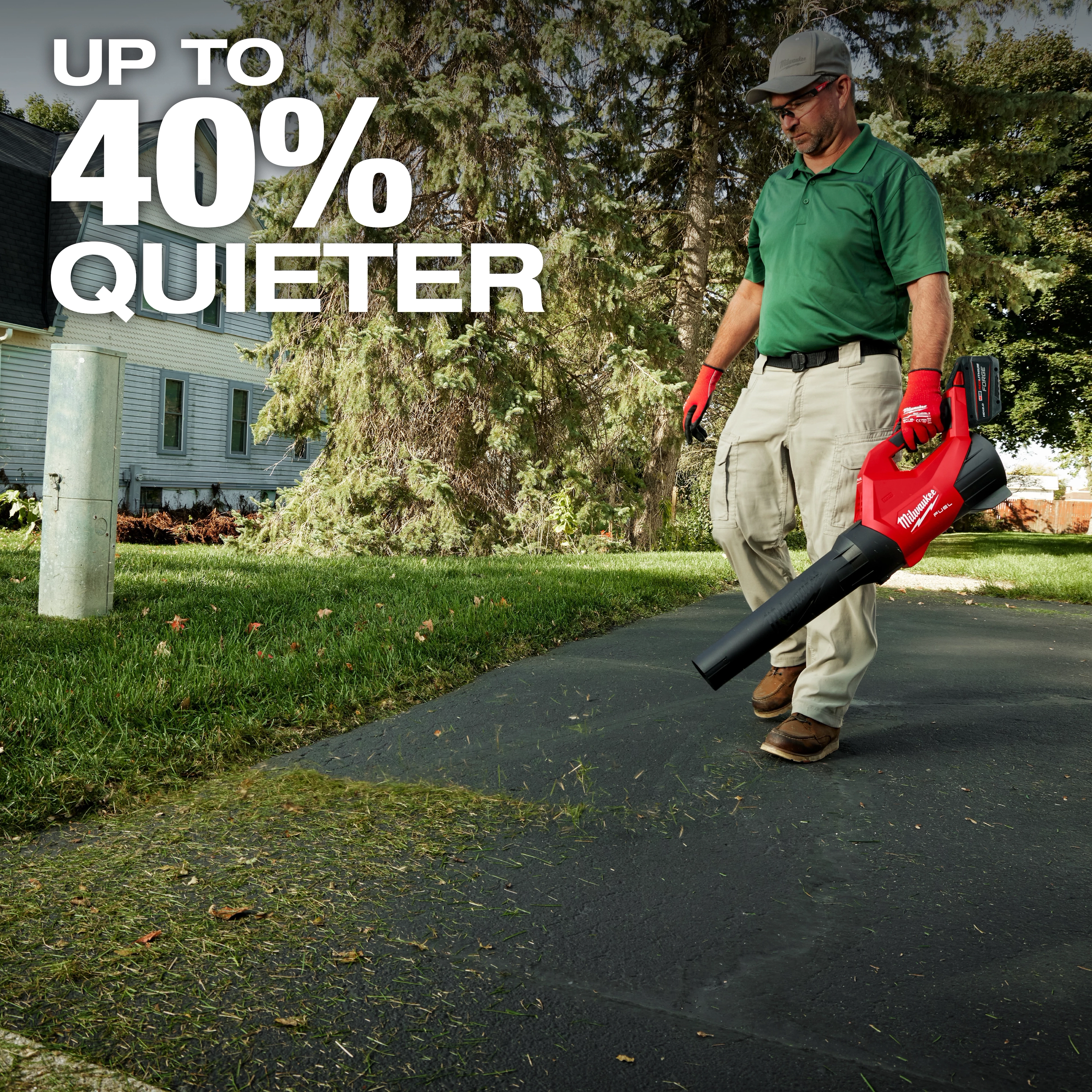 Person using a red leaf blower on a driveway with text "UP TO 40% QUIETER" in the upper left corner.