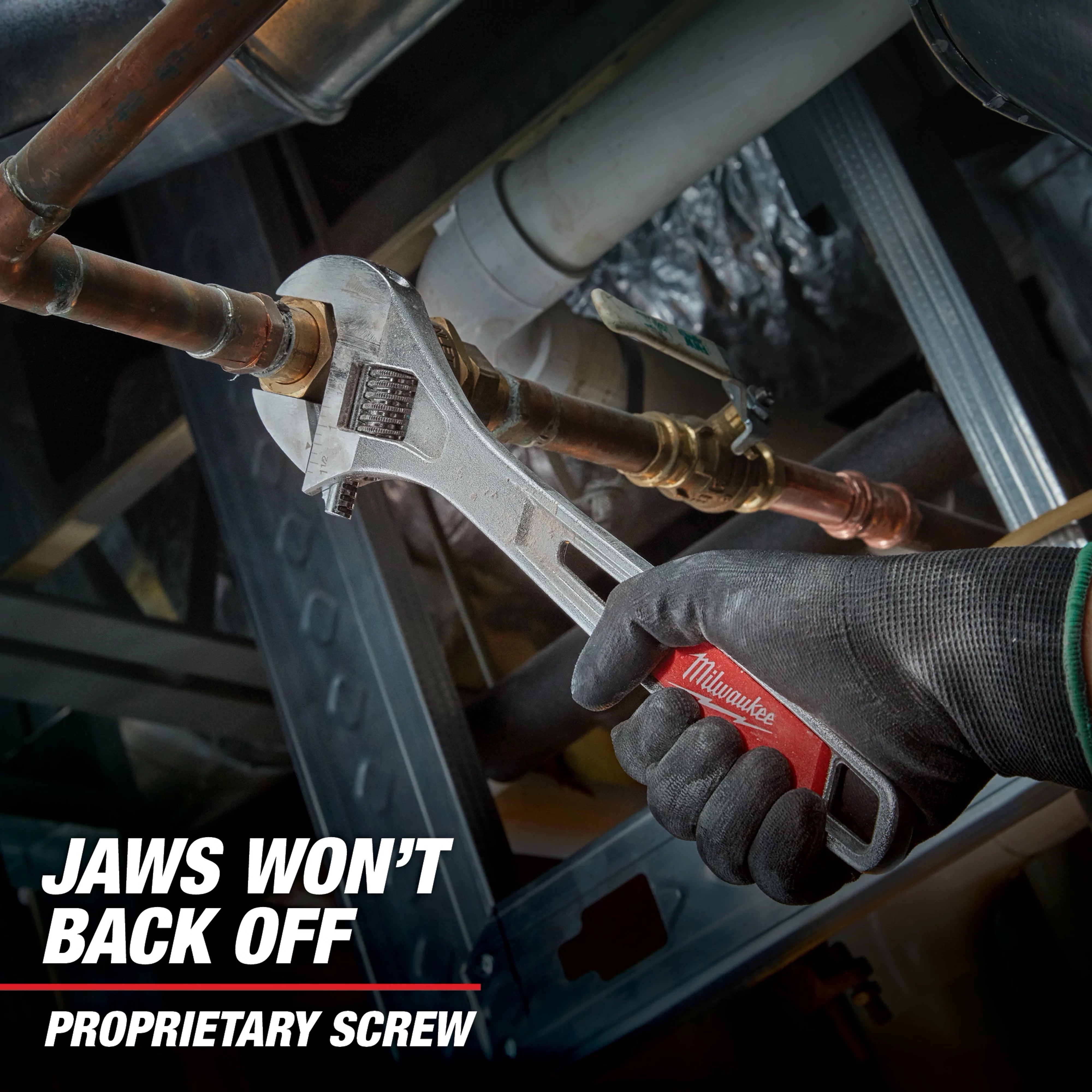 A Milwaukee adjustable wrench grips a metal pipe while held by a hand wearing a black glove. The text "JAWS WON'T BACK OFF PROPRIETARY SCREW" is displayed in the lower left corner.